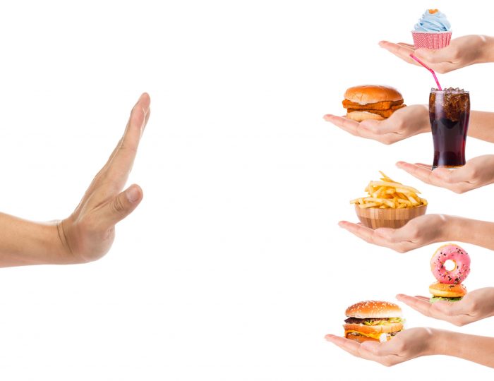Hand refusing junk food with white background